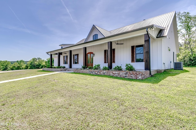 106 Horseshoe Ln, Flora, MS 39071 - modern farmhouse style home with a ceiling fan, covered porch, a front lawn, central air condition unit, and board and batten siding