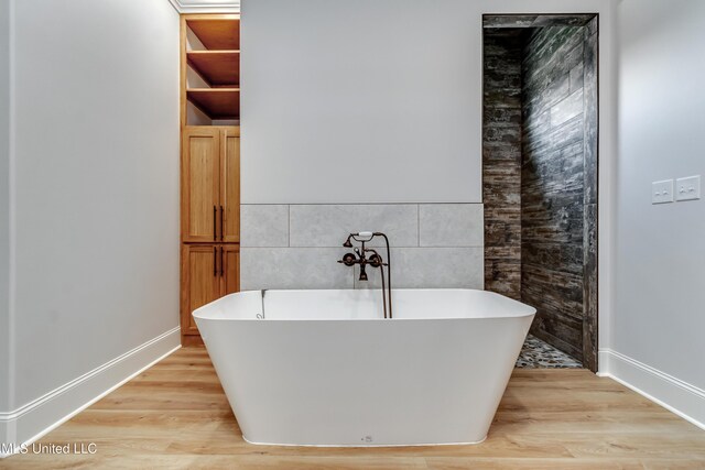 106 Horseshoe Ln, Flora, MS 39071 - bathroom featuring a freestanding bath, tile walls, wood finished floors, and baseboards