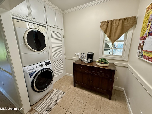 1331 Northwood Cir, Carthage, MS 39051 - laundry area featuring stacked washing machine and dryer, cabinet space, light tile patterned floors, and crown molding