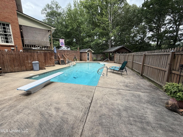 1331 Northwood Cir, Carthage, MS 39051 - view of swimming pool with a fenced backyard, a diving board, a storage unit, stairway, and a patio area