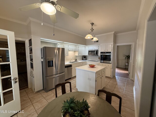 1331 Northwood Cir, Carthage, MS 39051 - kitchen with stainless steel appliances, crown molding, white cabinets, light countertops, and a center island