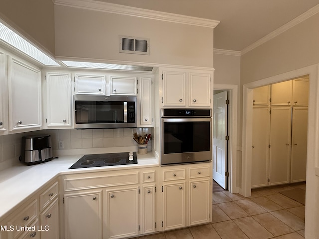 1331 Northwood Cir, Carthage, MS 39051 - kitchen featuring appliances with stainless steel finishes, crown molding, tasteful backsplash, light tile patterned flooring, and light countertops