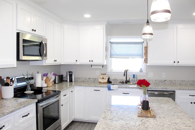 kitchen featuring recessed lighting, stainless steel appliances, a sink, white cabinets, and decorative light fixtures