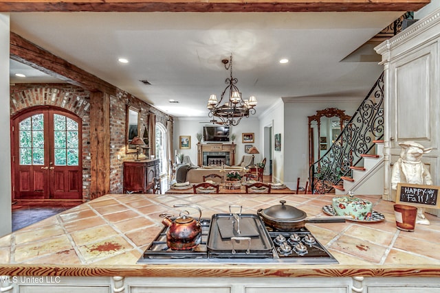 338 Hillview Dr, Ridgeland, MS 39157 - interior space with stainless steel gas stovetop, french doors, pendant lighting, a chandelier, and crown molding