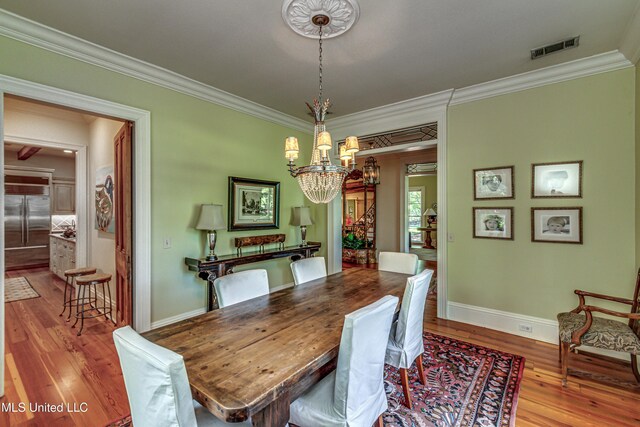 338 Hillview Dr, Ridgeland, MS 39157 - dining space with light wood-type flooring, crown molding, and a notable chandelier