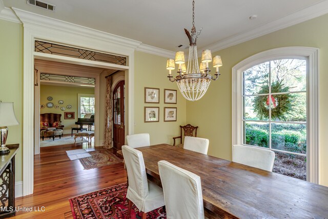 338 Hillview Dr, Ridgeland, MS 39157 - dining room featuring wood-type flooring, ornamental molding, and a notable chandelier