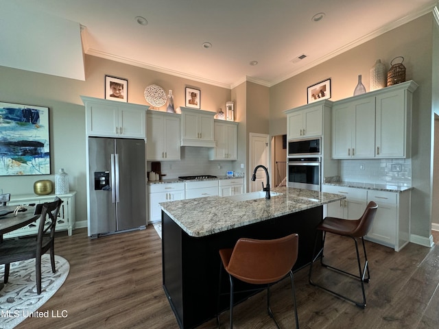 kitchen featuring white cabinetry, stainless steel appliances, dark hardwood / wood-style flooring, and an island with sink