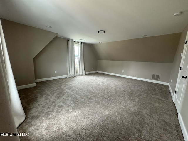 bonus room featuring dark carpet and lofted ceiling