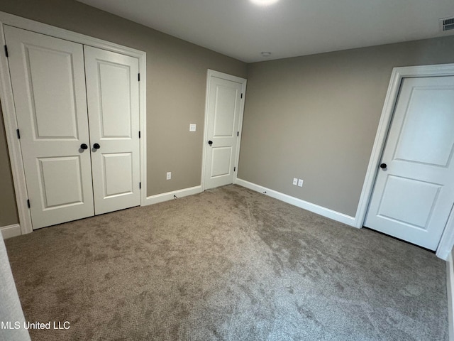 unfurnished bedroom with light carpet and a closet