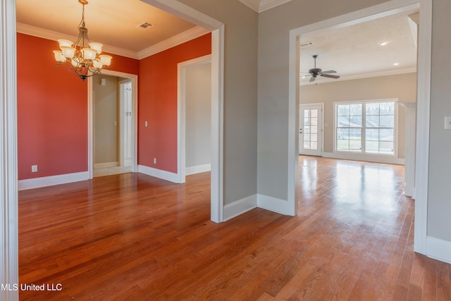 spare room featuring wood-type flooring, ceiling fan with notable chandelier, and crown molding