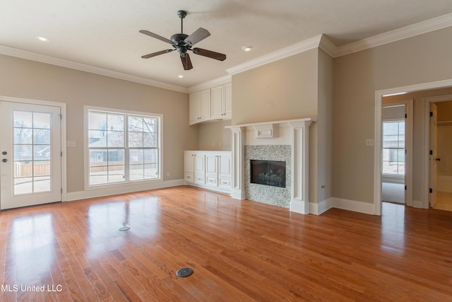 unfurnished living room with light hardwood / wood-style flooring, ornamental molding, and ceiling fan