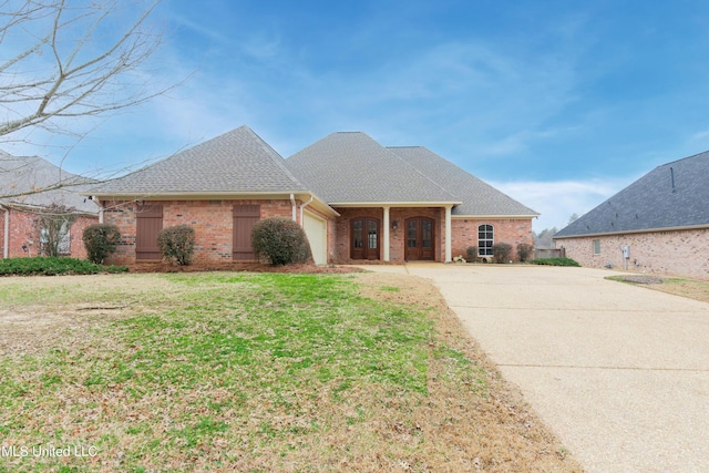 single story home featuring a garage and a front yard