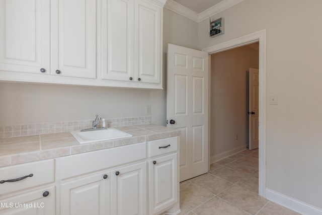 interior space with sink, light tile patterned floors, and ornamental molding