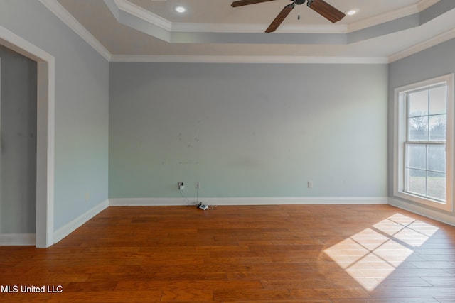 unfurnished room featuring light hardwood / wood-style flooring, ornamental molding, a raised ceiling, and ceiling fan