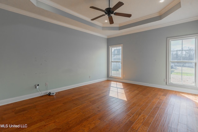 spare room featuring wood-type flooring, ceiling fan, crown molding, and a tray ceiling