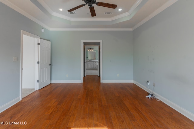 spare room with crown molding, hardwood / wood-style floors, ceiling fan, and a tray ceiling