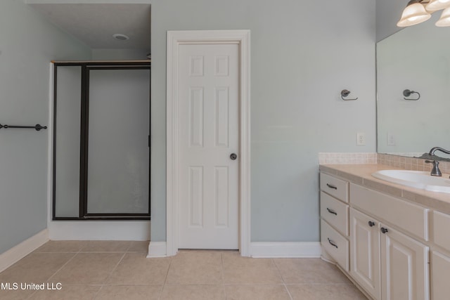 bathroom featuring tile patterned flooring, vanity, and a shower with door