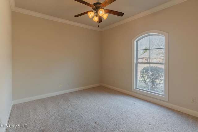 carpeted spare room with a wealth of natural light, ornamental molding, and ceiling fan