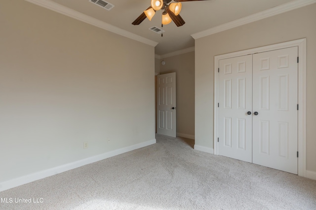 unfurnished bedroom with crown molding, ceiling fan, carpet, and a closet