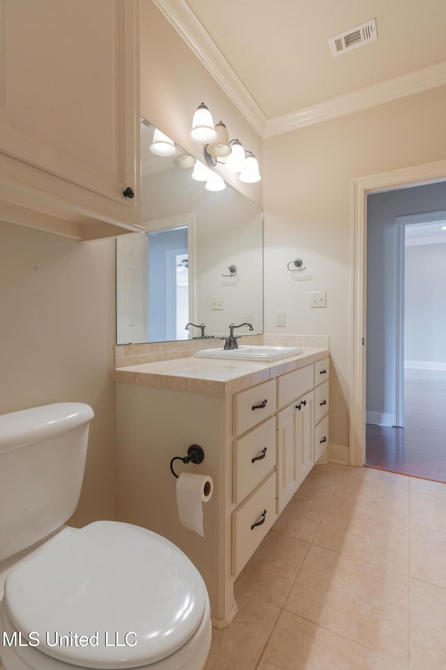 bathroom with crown molding, vanity, tile patterned floors, and toilet