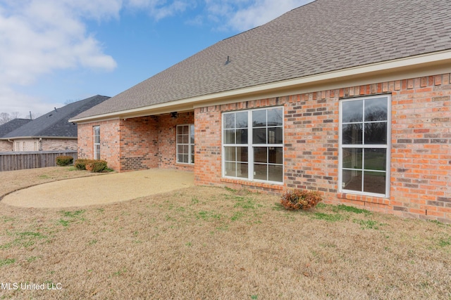 back of property with a yard and a patio area