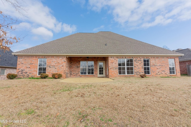 back of property with a yard and a patio area