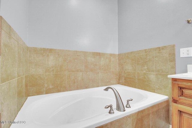 full bath with a garden tub and vanity