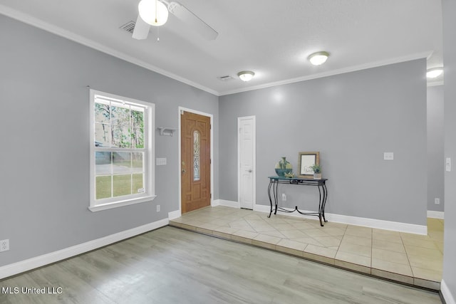 tiled entryway with baseboards, ornamental molding, and a ceiling fan