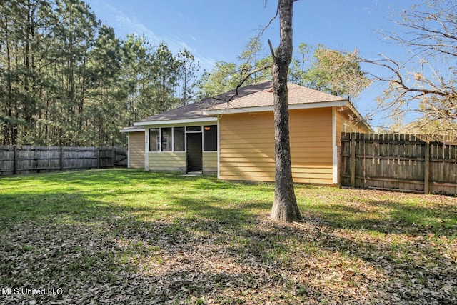 back of property featuring a yard and a fenced backyard