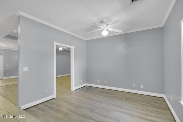 spare room featuring visible vents, wood finished floors, crown molding, baseboards, and ceiling fan