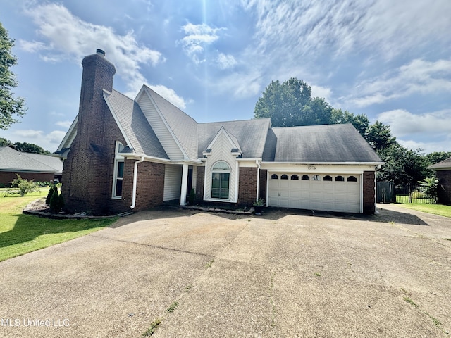 7264 Flower Creek Dr, Southaven, MS 38671 - view of front of home featuring brick siding, asphalt driveway, a garage, and a chimney