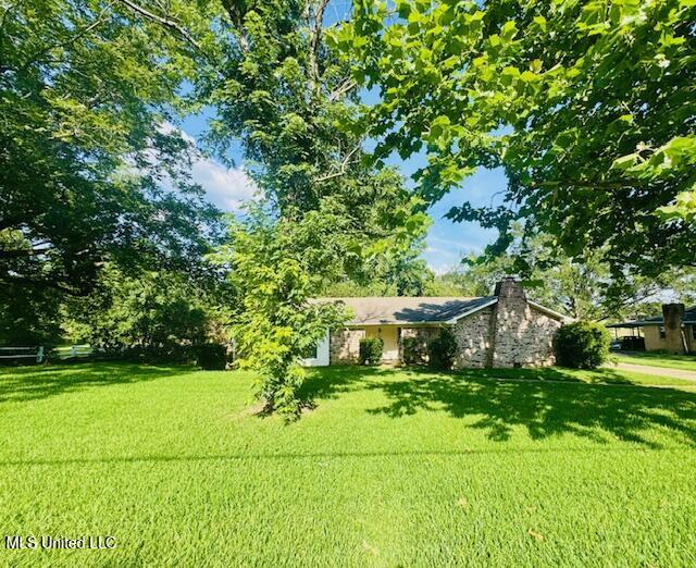 3864 S Siwell Rd, Jackson, MS 39212 - view of front of house with a front yard and a chimney