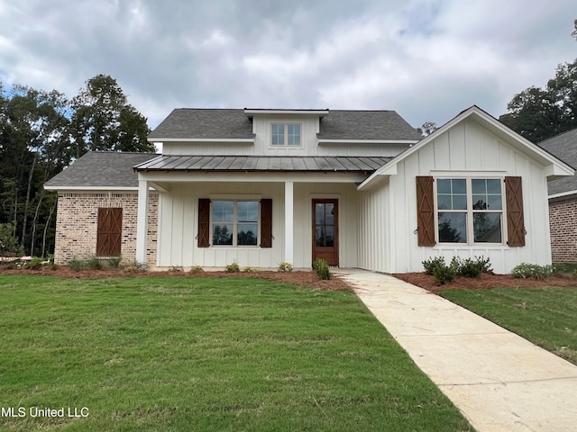 view of front of property featuring covered porch and a front lawn