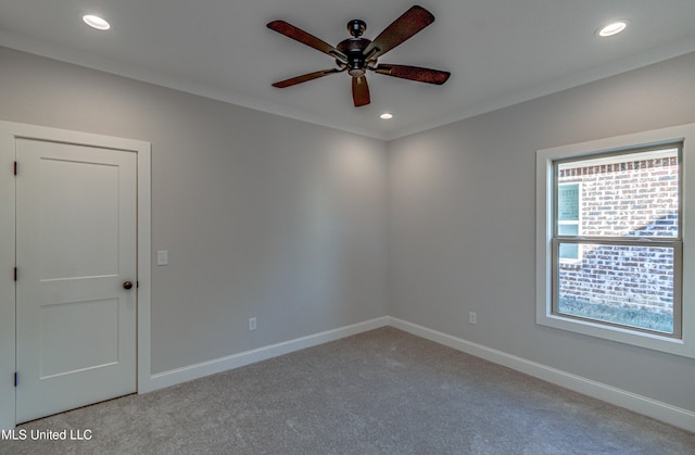 carpeted empty room with ceiling fan and ornamental molding