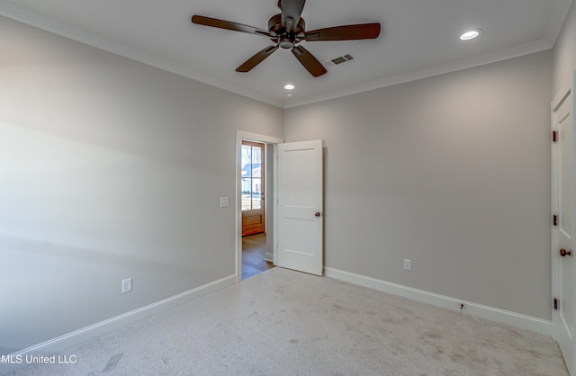 spare room featuring light colored carpet, ceiling fan, and ornamental molding