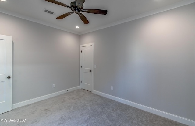 carpeted spare room featuring ceiling fan and crown molding