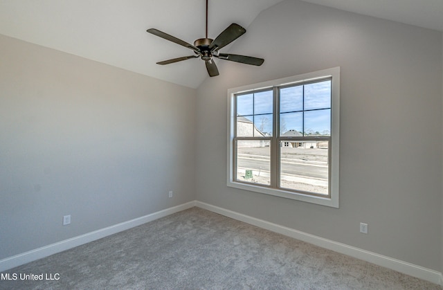 spare room with light colored carpet, vaulted ceiling, and ceiling fan