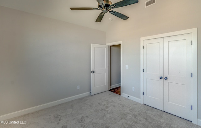 unfurnished bedroom with lofted ceiling, light colored carpet, a closet, and ceiling fan