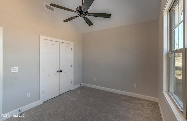 unfurnished bedroom with ceiling fan, multiple windows, a closet, and lofted ceiling