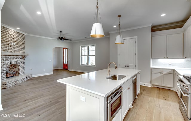 kitchen featuring sink, white cabinets, a kitchen island with sink, and appliances with stainless steel finishes