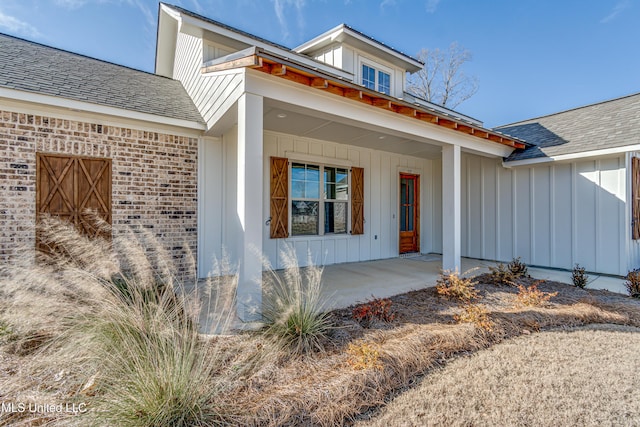 601 Cobalt Way, Brandon, MS 39042 - doorway to property featuring brick siding, a porch, board and batten siding, and a shingled roof