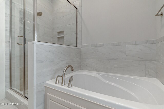 bathroom featuring shower with separate bathtub