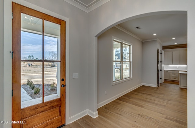 entrance foyer featuring crown molding and light wood-type flooring