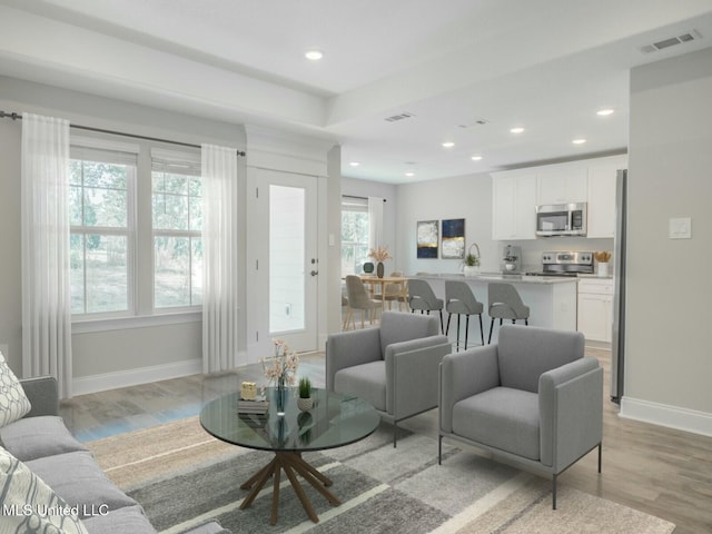 living area featuring recessed lighting, baseboards, visible vents, and light wood finished floors