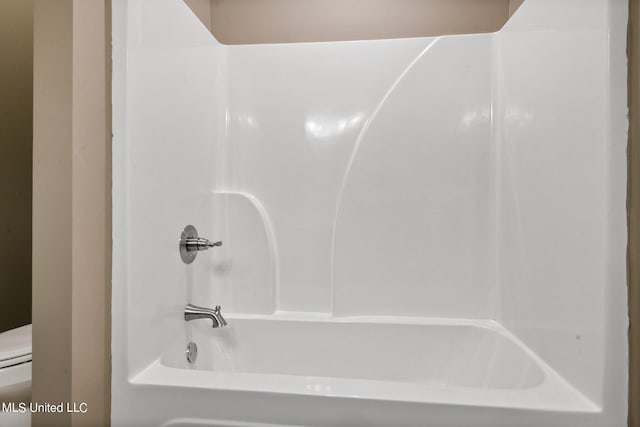 bathroom featuring toilet and bathtub / shower combination