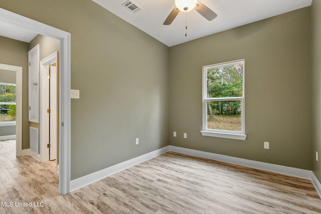 spare room with visible vents, ceiling fan, light wood-style flooring, and baseboards