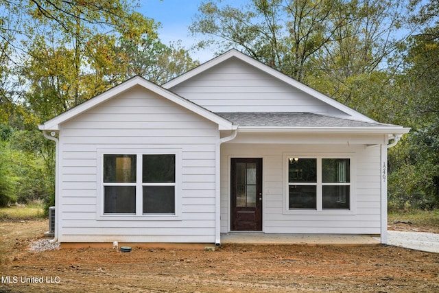 bungalow-style house featuring central air condition unit and roof with shingles
