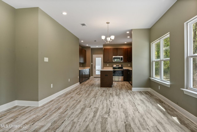 kitchen with recessed lighting, an inviting chandelier, appliances with stainless steel finishes, light countertops, and light wood-type flooring