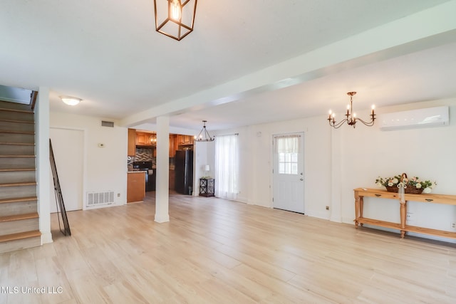 103 Woodlark Cir, Carriere, MS 39426 - unfurnished living room with an AC wall unit, a chandelier, stairs, and light wood-type flooring