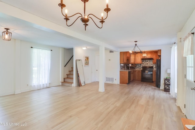 103 Woodlark Cir, Carriere, MS 39426 - unfurnished living room with a chandelier, light wood-style flooring, and stairway
